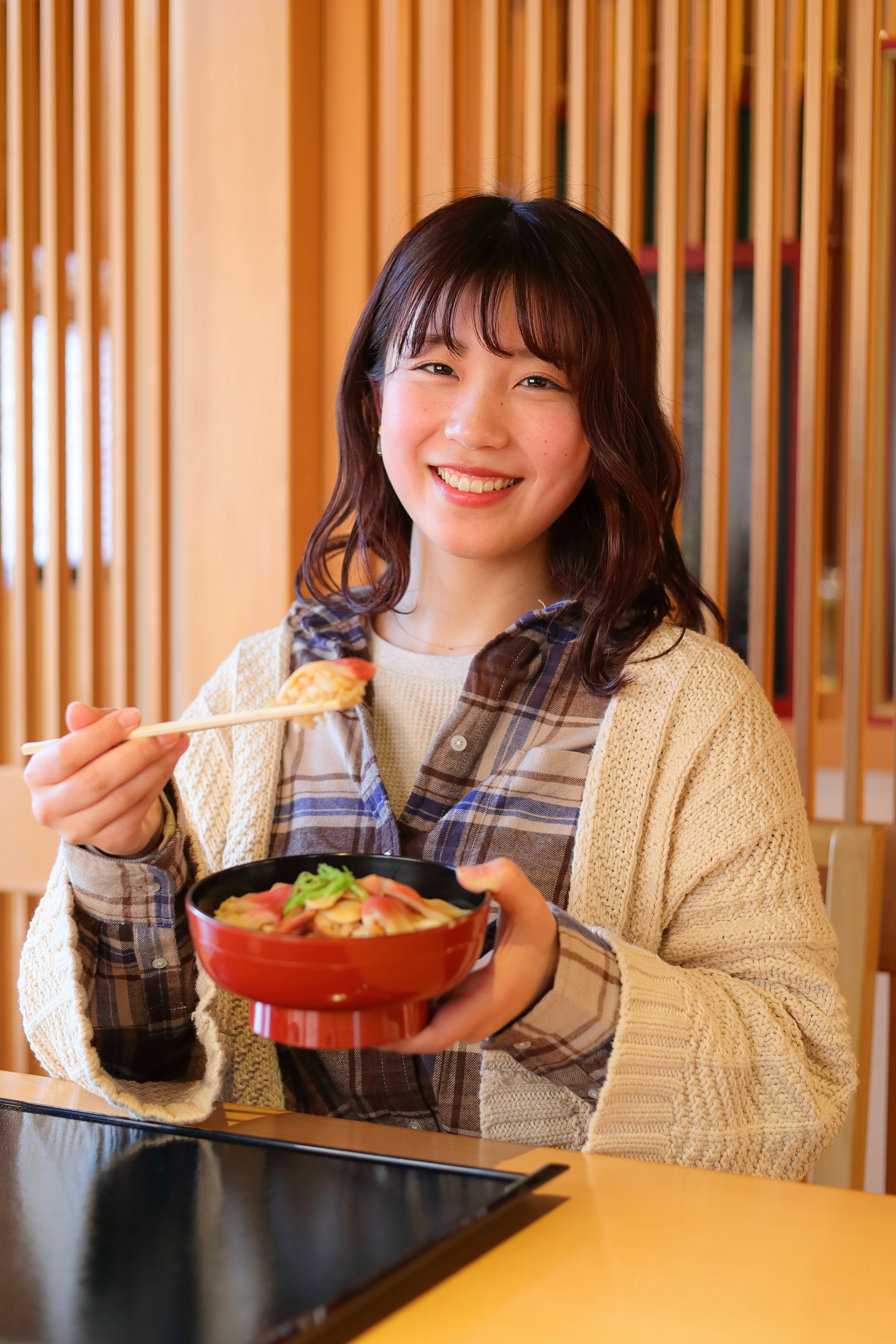 ほっきめしを食べる女性の写真