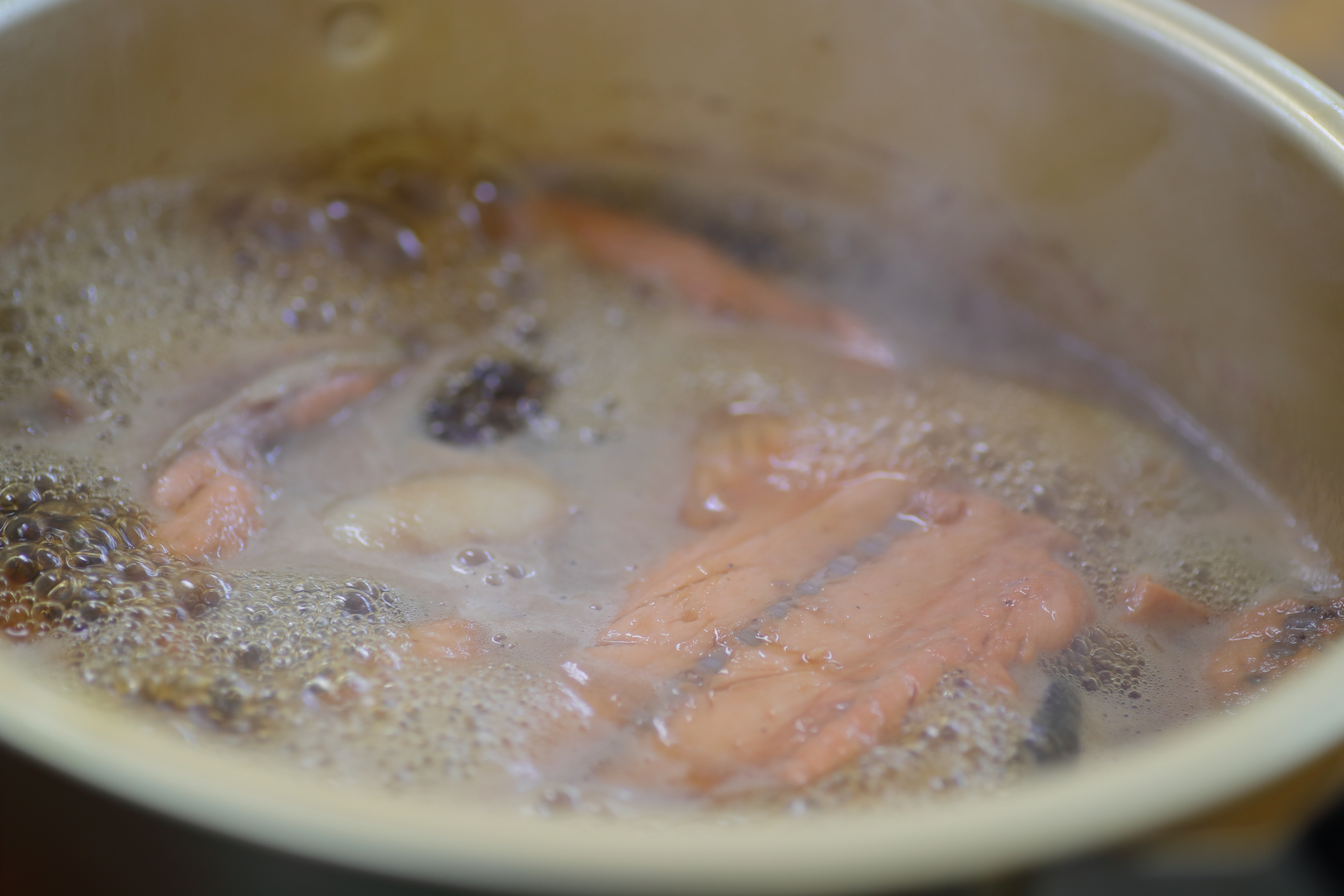 タレにアラや中骨を加えて煮込んでいきます。煮汁はご飯を炊くのに使います。