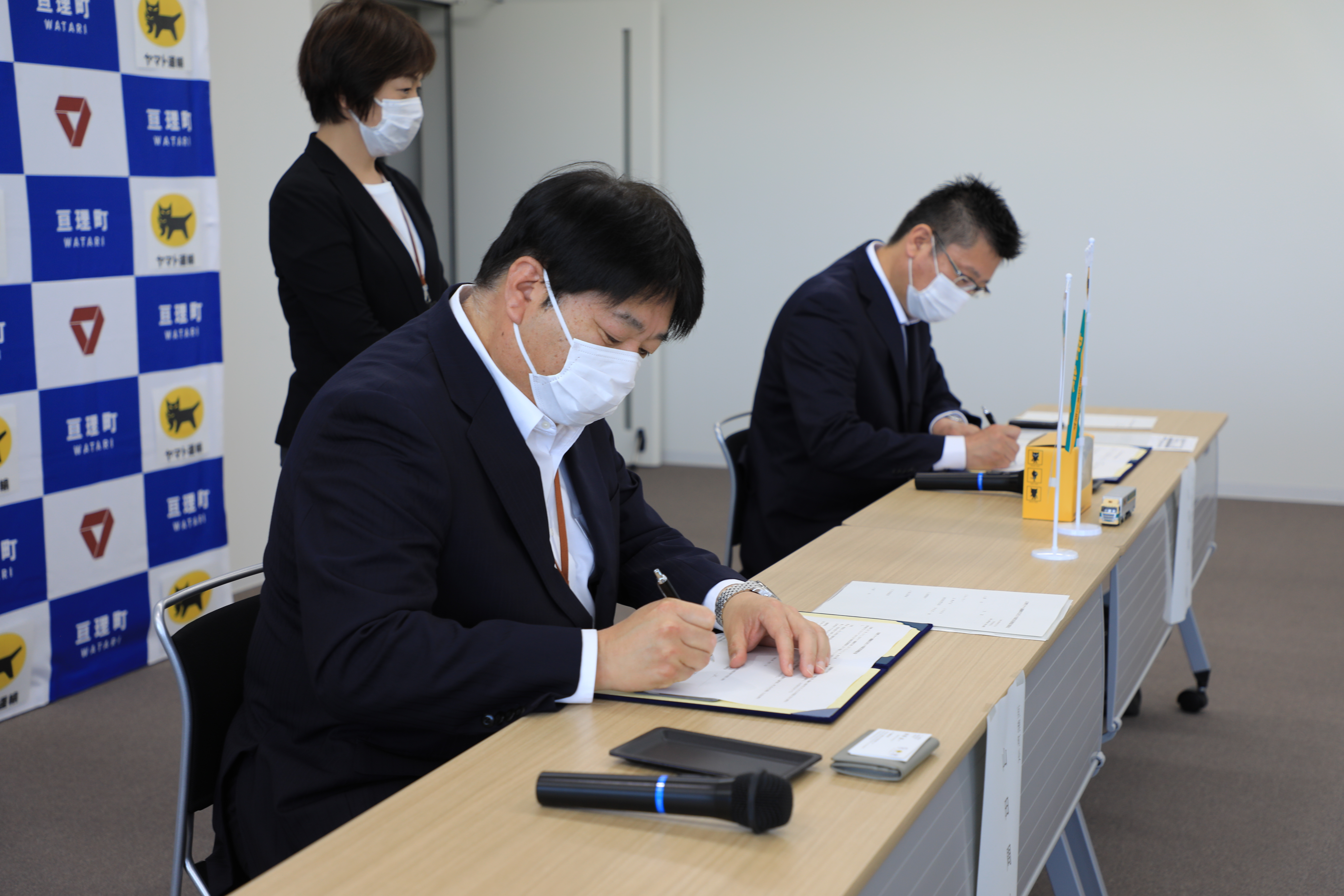 代表者2名が署名している様子