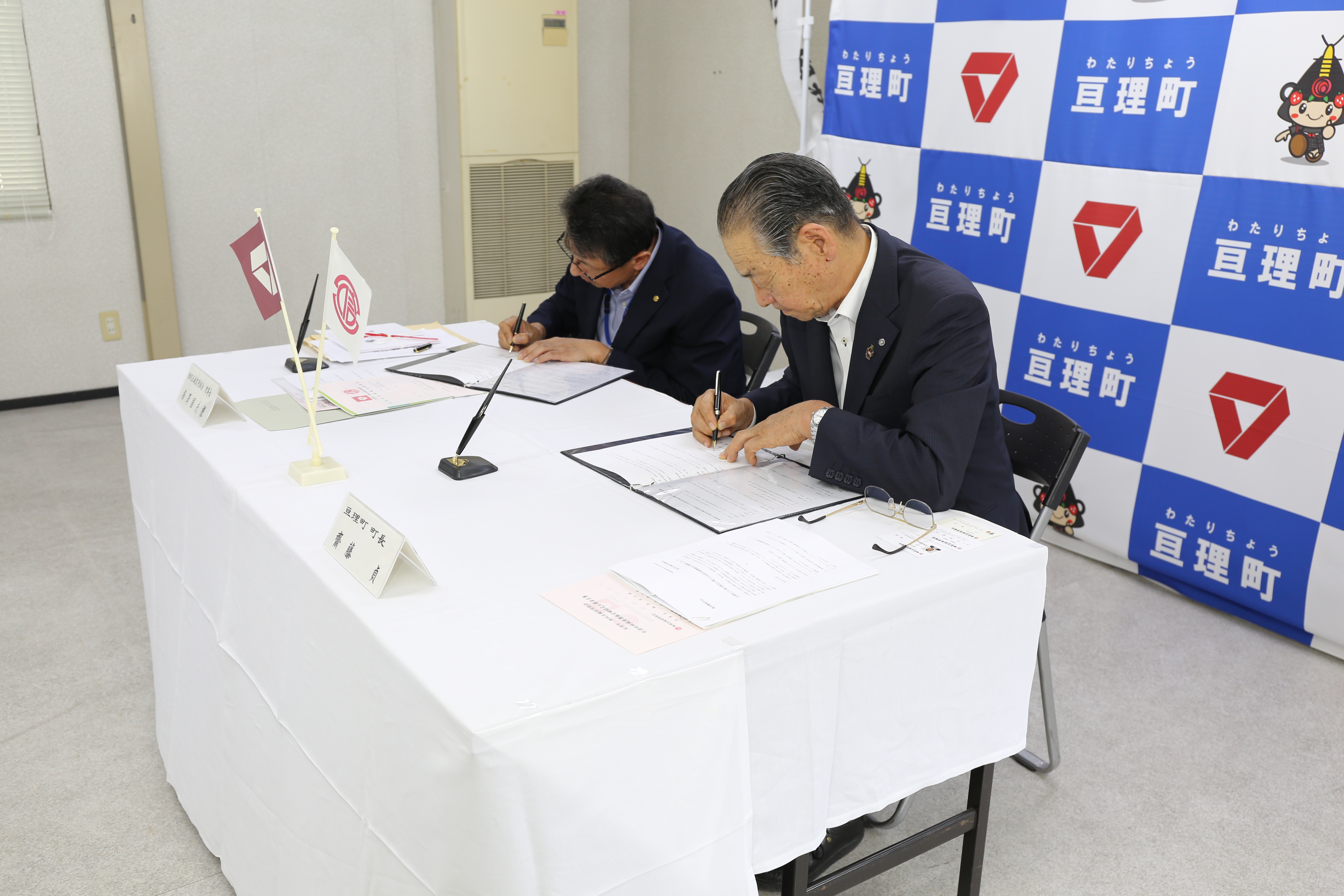 代表者2名が署名している様子